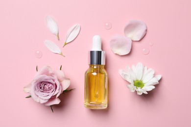 Bottle of cosmetic serum and beautiful flowers on pink background, flat lay