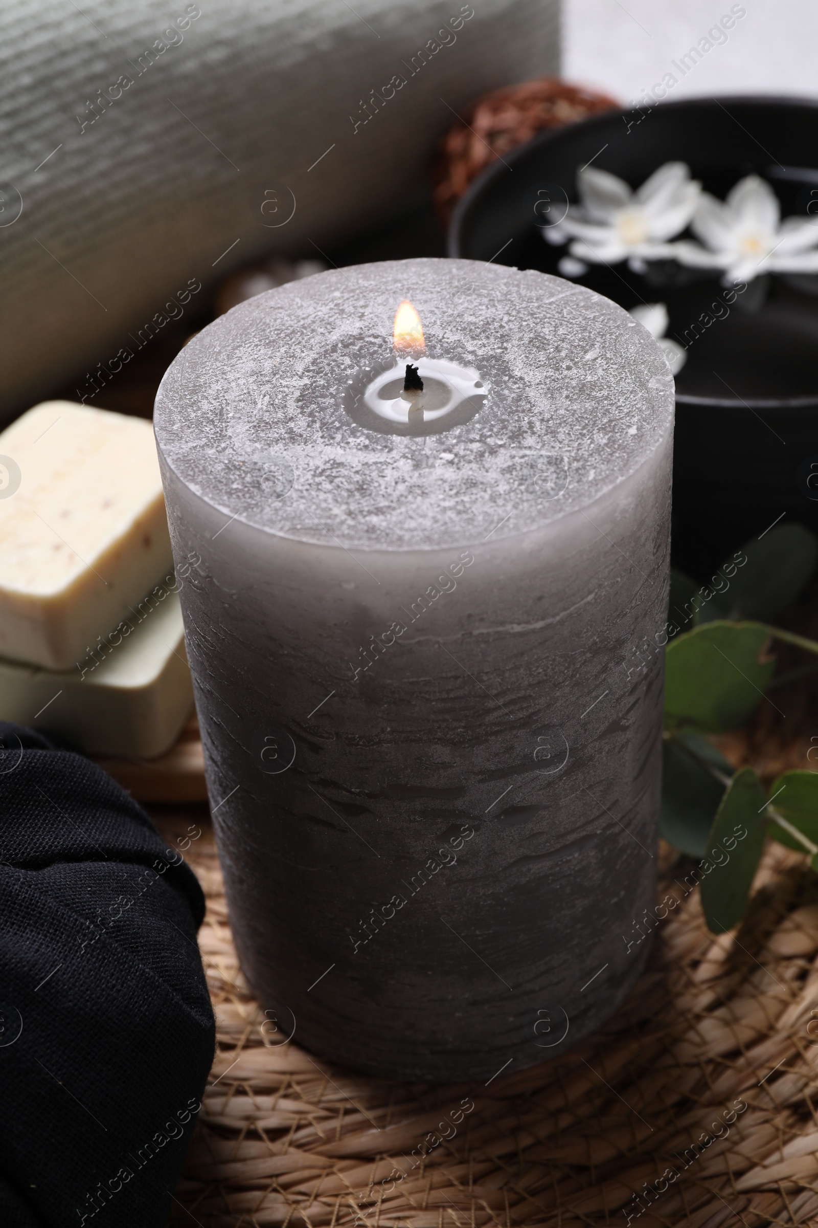 Photo of Beautiful composition with burning candle and spa products on table,closeup