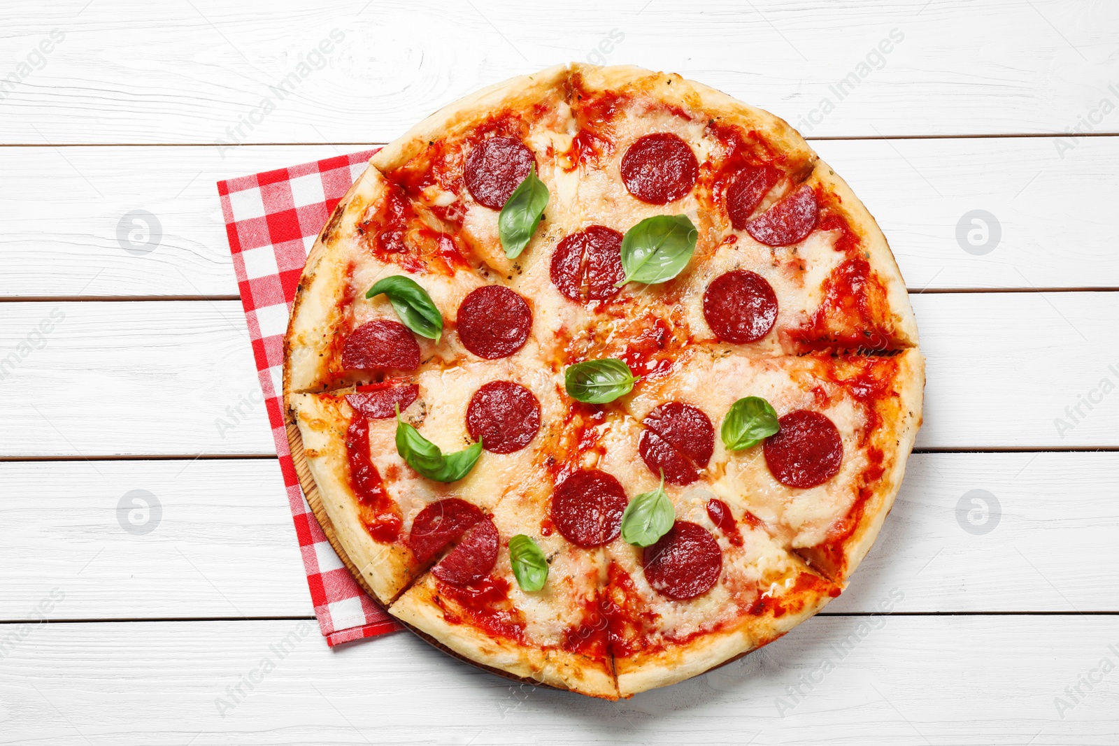 Photo of Hot delicious pepperoni pizza on white wooden table, top view