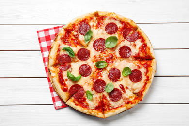 Photo of Hot delicious pepperoni pizza on white wooden table, top view