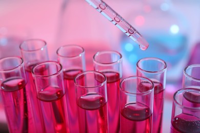 Photo of Dripping reagent into test tube with red liquid, closeup. Laboratory analysis