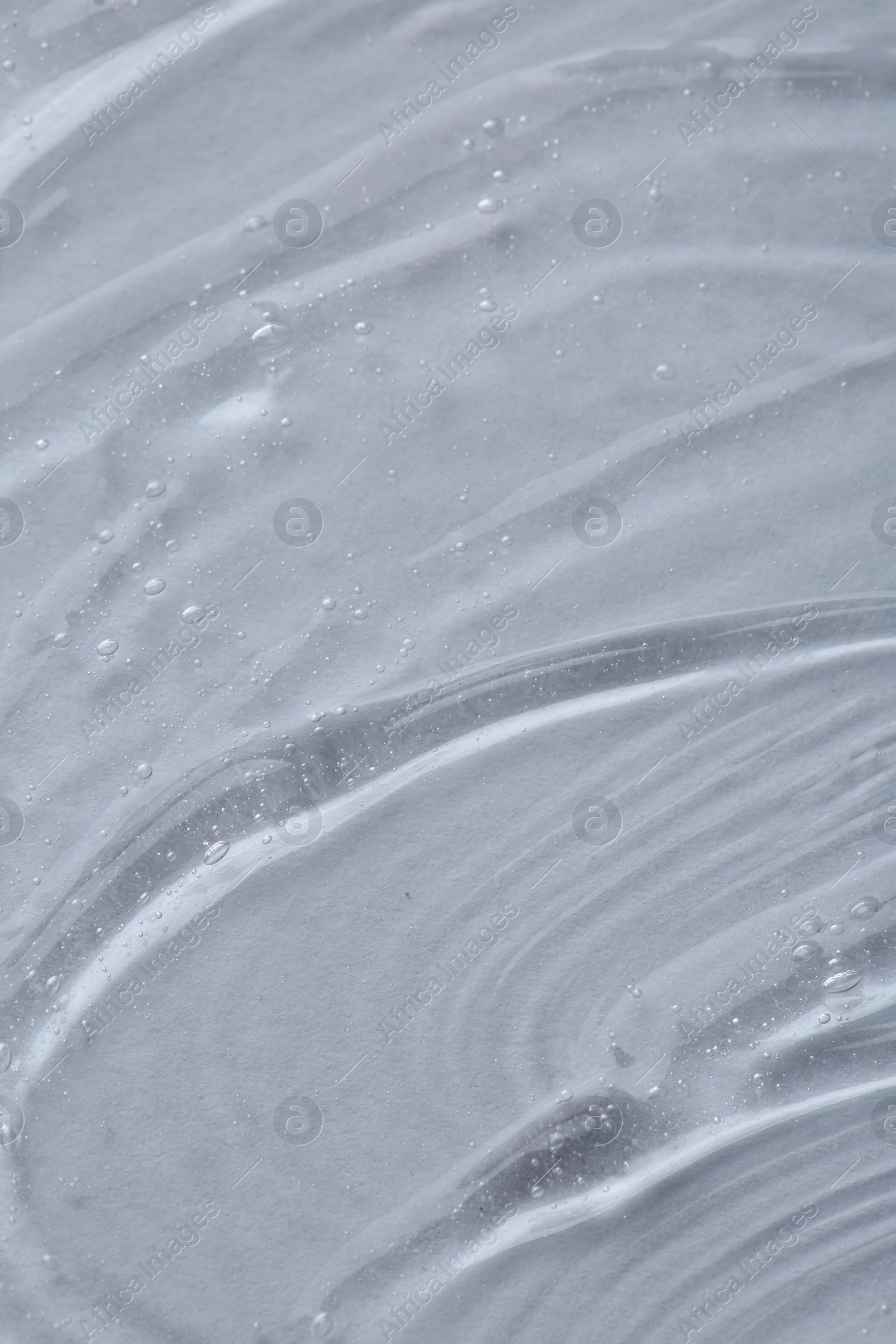 Photo of Clear cosmetic serum on white background, macro view