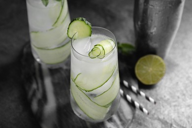 Photo of Refreshing cucumber water on dark grey table, closeup