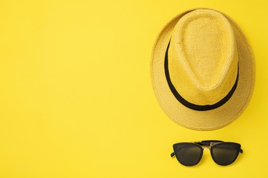 Photo of Hat and sunglasses on yellow background, flat lay with space for text. Sun protection