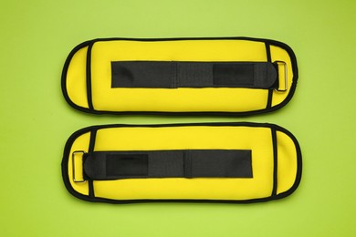 Photo of Yellow weighting agents on light green background, flat lay