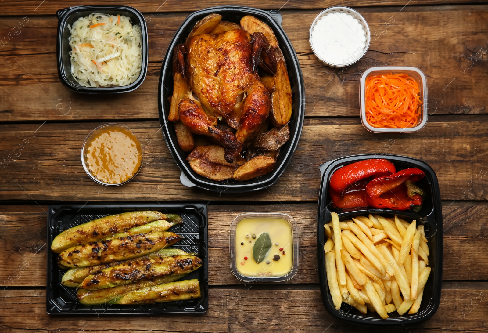 Photo of Plastic containers with different dishes on wooden table, flat lay. Food delivery service