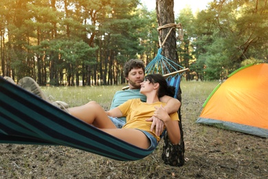 Lovely couple resting in comfortable hammock outdoors