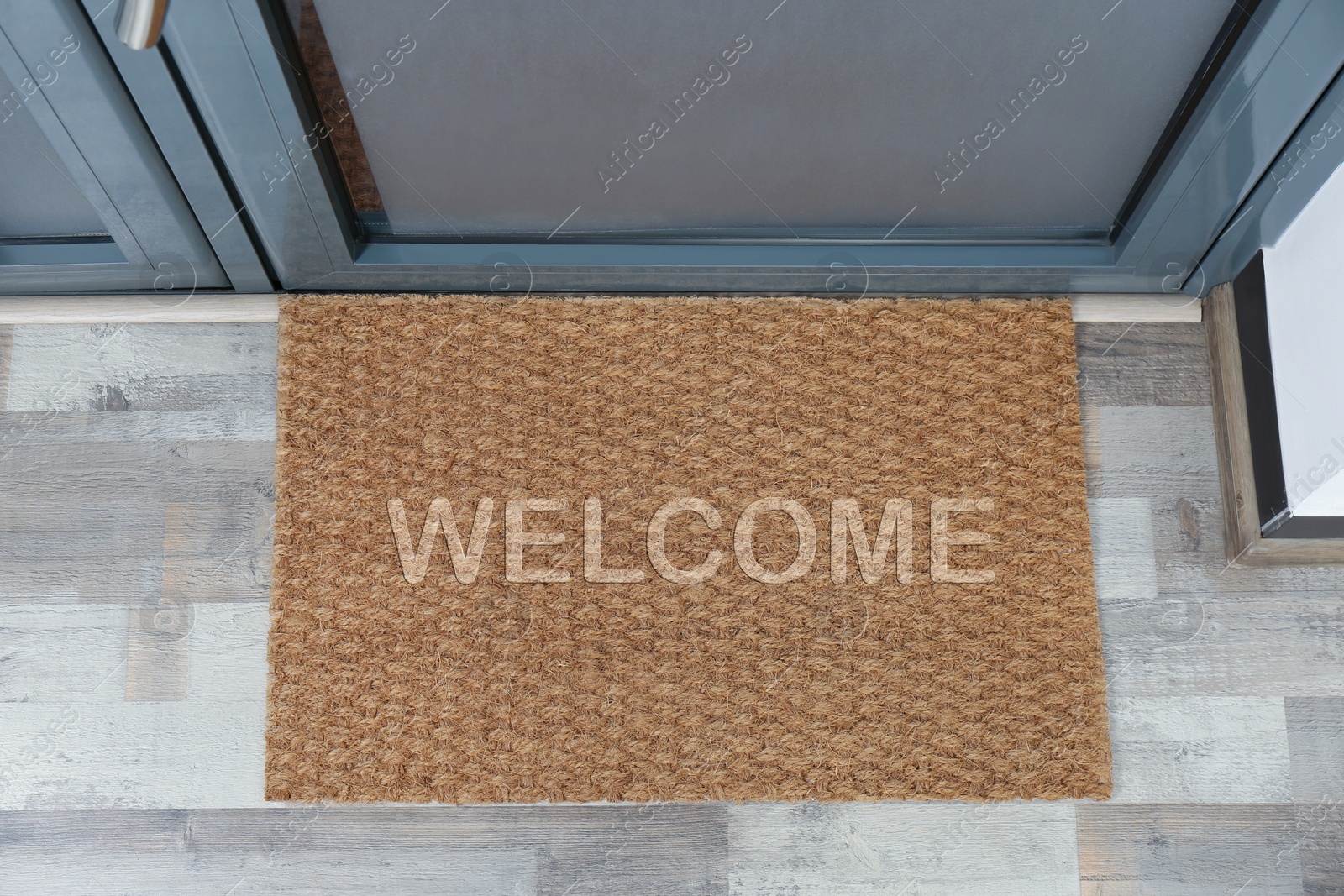 Image of Door mat with word WELCOME near entrance, top view