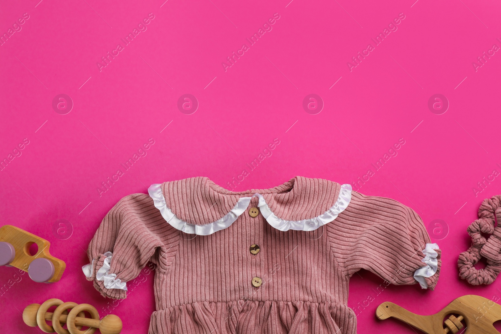 Photo of Flat lay composition with baby clothes and accessories on pink background, space for text