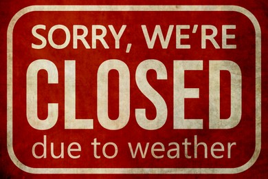 Image of Sorry we are closed due to weather sign. Text and snowflakes on red background
