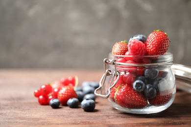 Mix of ripe berries on wooden table. Space for text