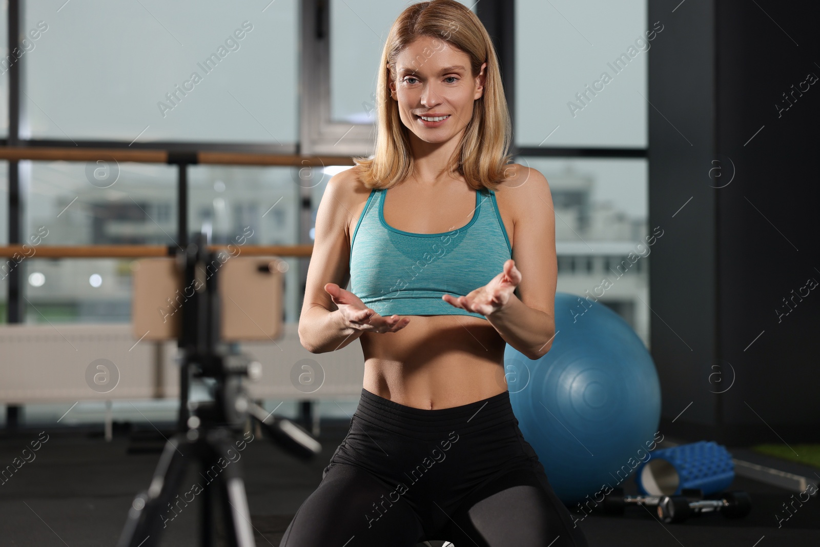 Photo of Fitness trainer recording online classes in gym