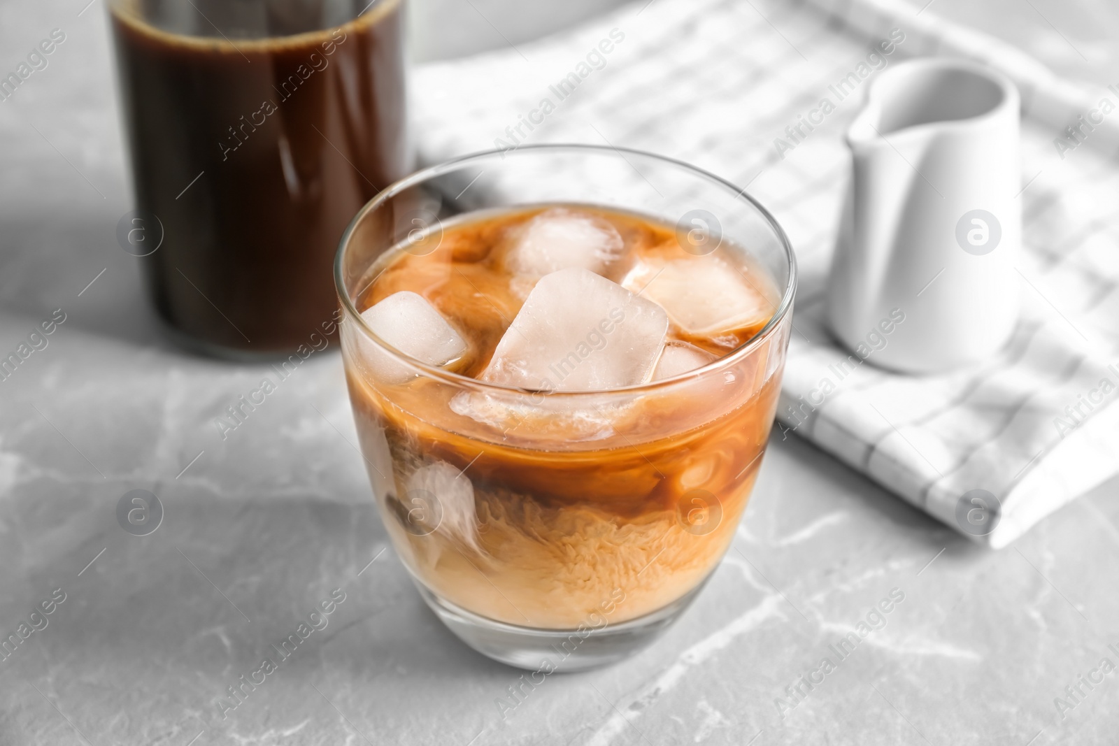 Photo of Glass with cold brew coffee and milk on light background