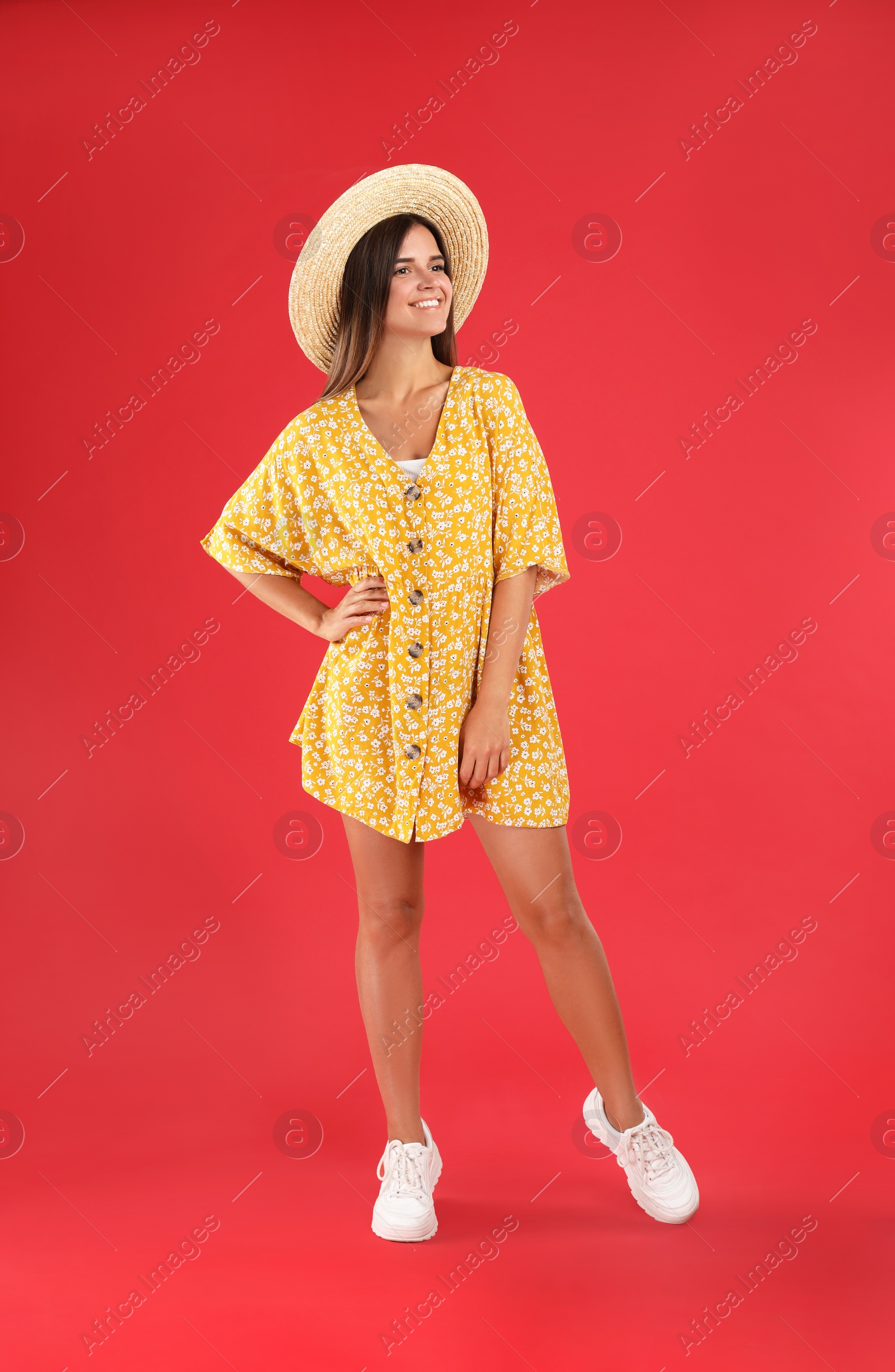 Photo of Young woman wearing stylish yellow dress on red background