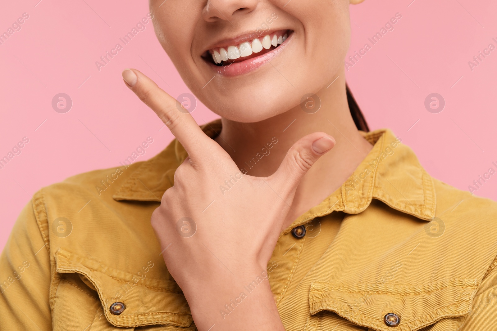 Photo of Woman with clean teeth smiling on pink background, closeup