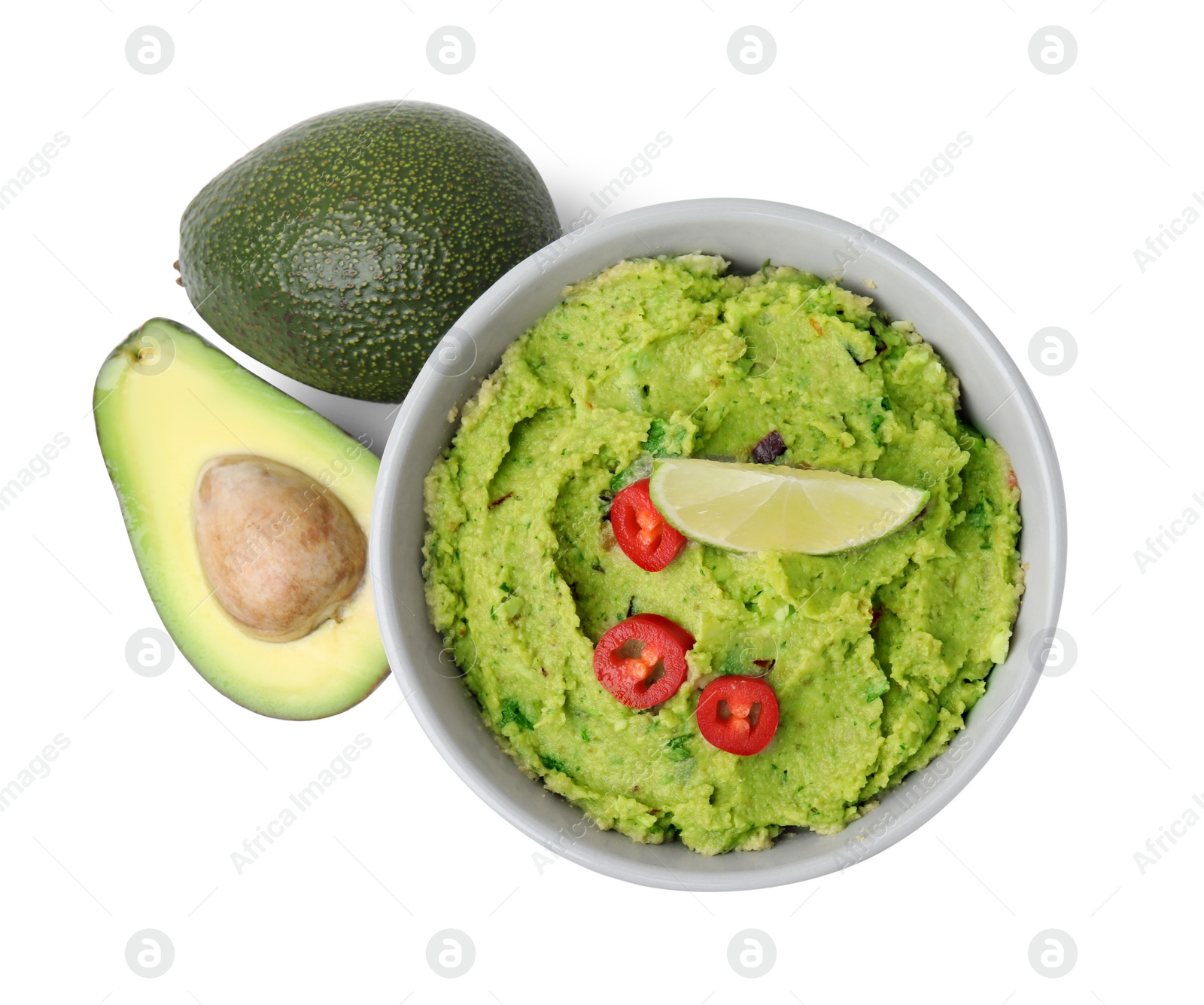 Photo of Bowl of delicious guacamole and fresh avocados isolated on white, top view