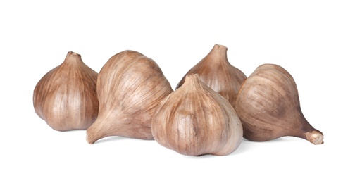 Photo of Unpeeled bulbs of black garlic on white background