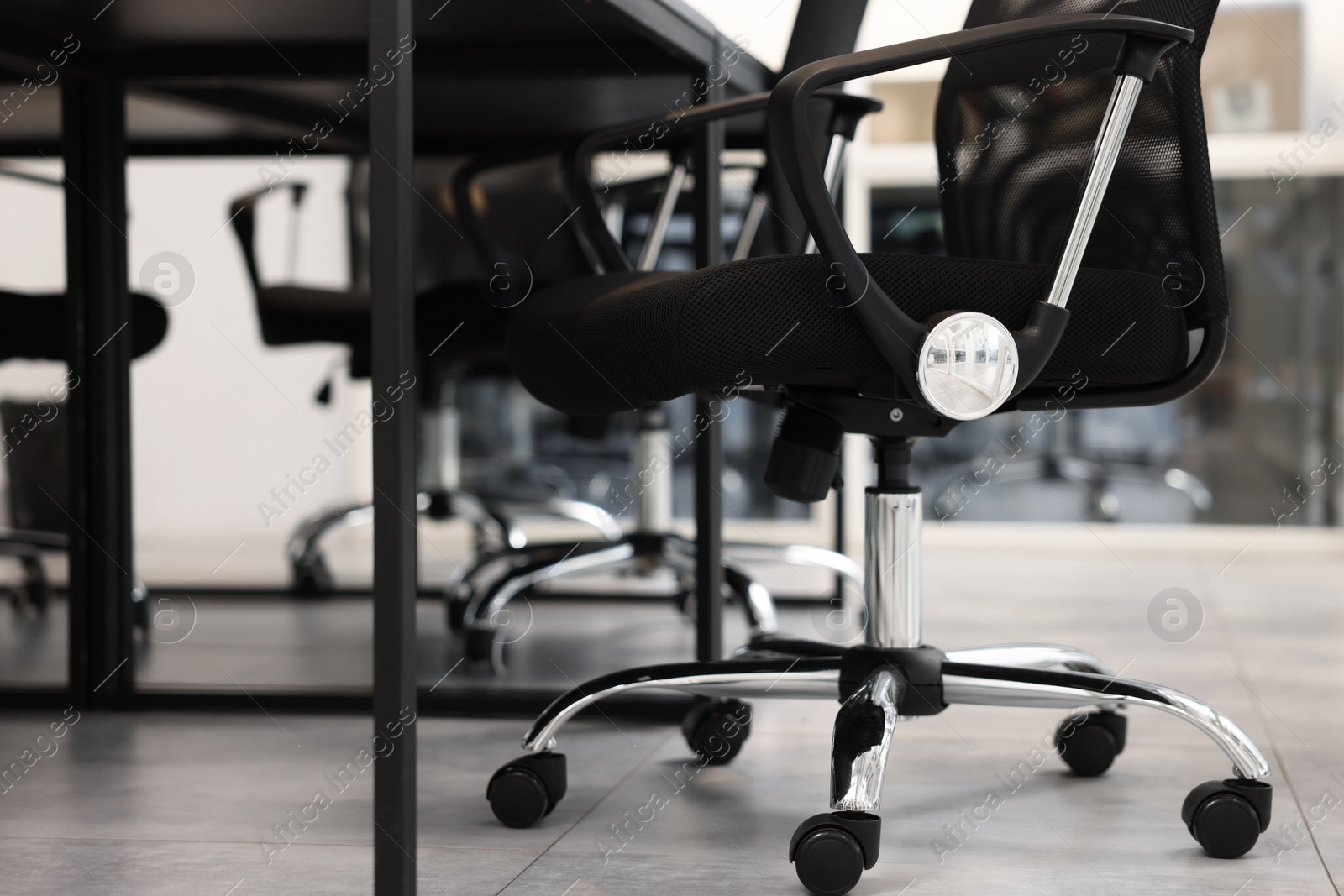 Photo of Comfortable office chairs and tables in meeting room, closeup