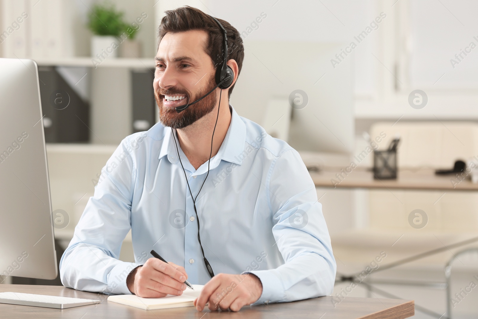 Photo of Hotline operator with headset working in office