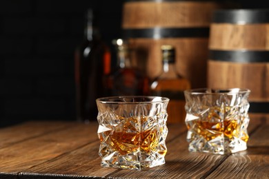 Photo of Tasty whiskey on wooden table, space for text