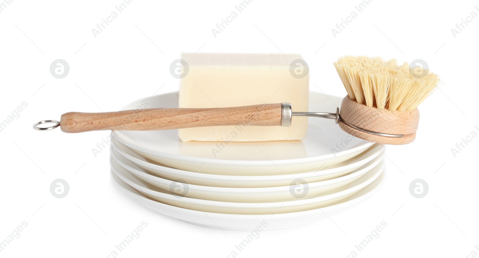 Photo of Cleaning brush and soap bar for dish washing on plates against white background