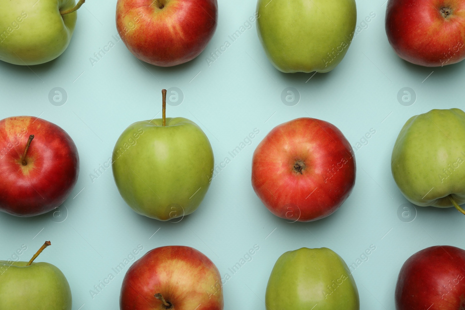 Photo of Fresh colorful apples on light blue background, flat lay