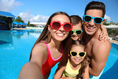 Photo of Happy family taking selfie near swimming pool.  Summer vacation