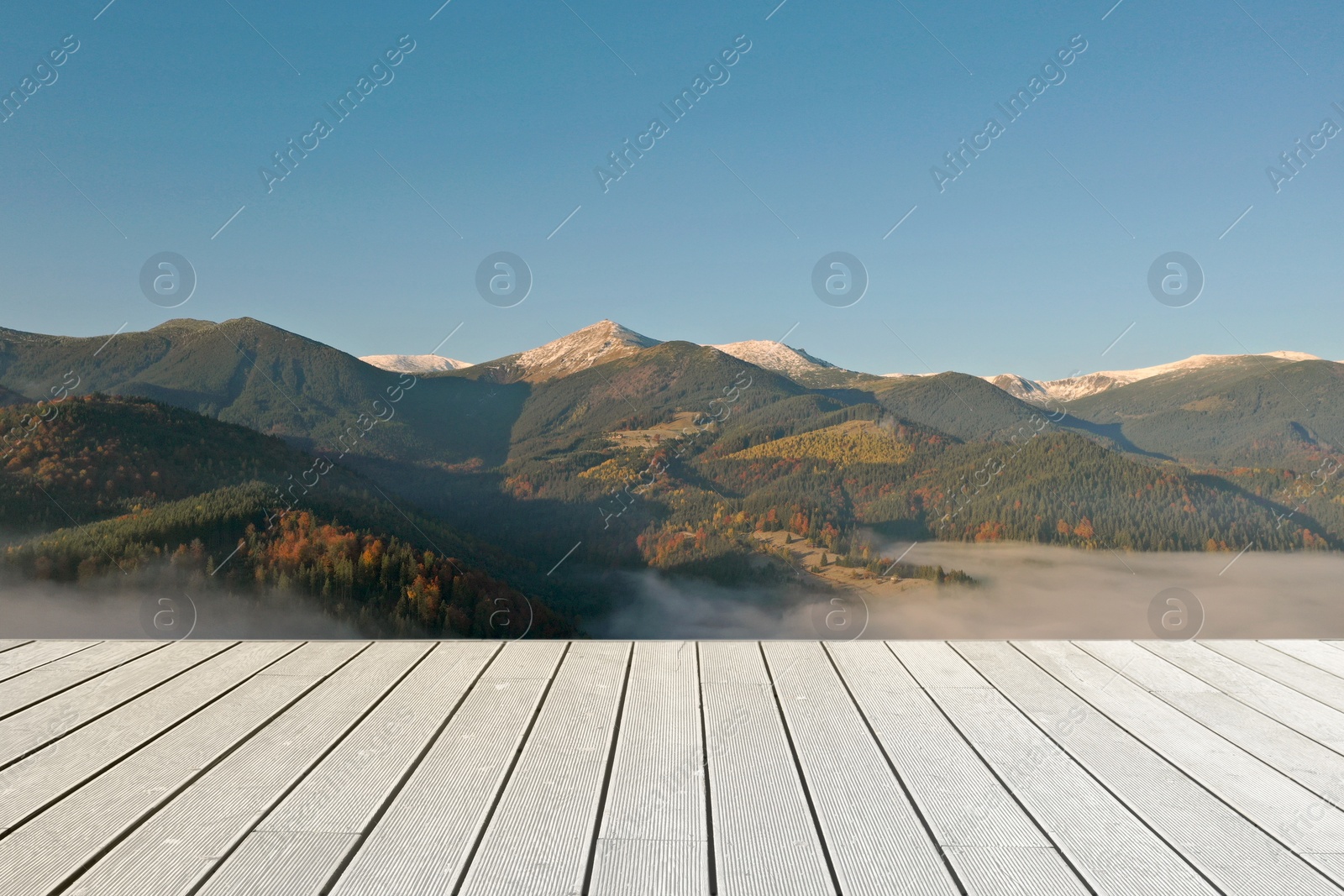 Image of Empty wooden surface and beautiful view of landscape with thick mist in mountains