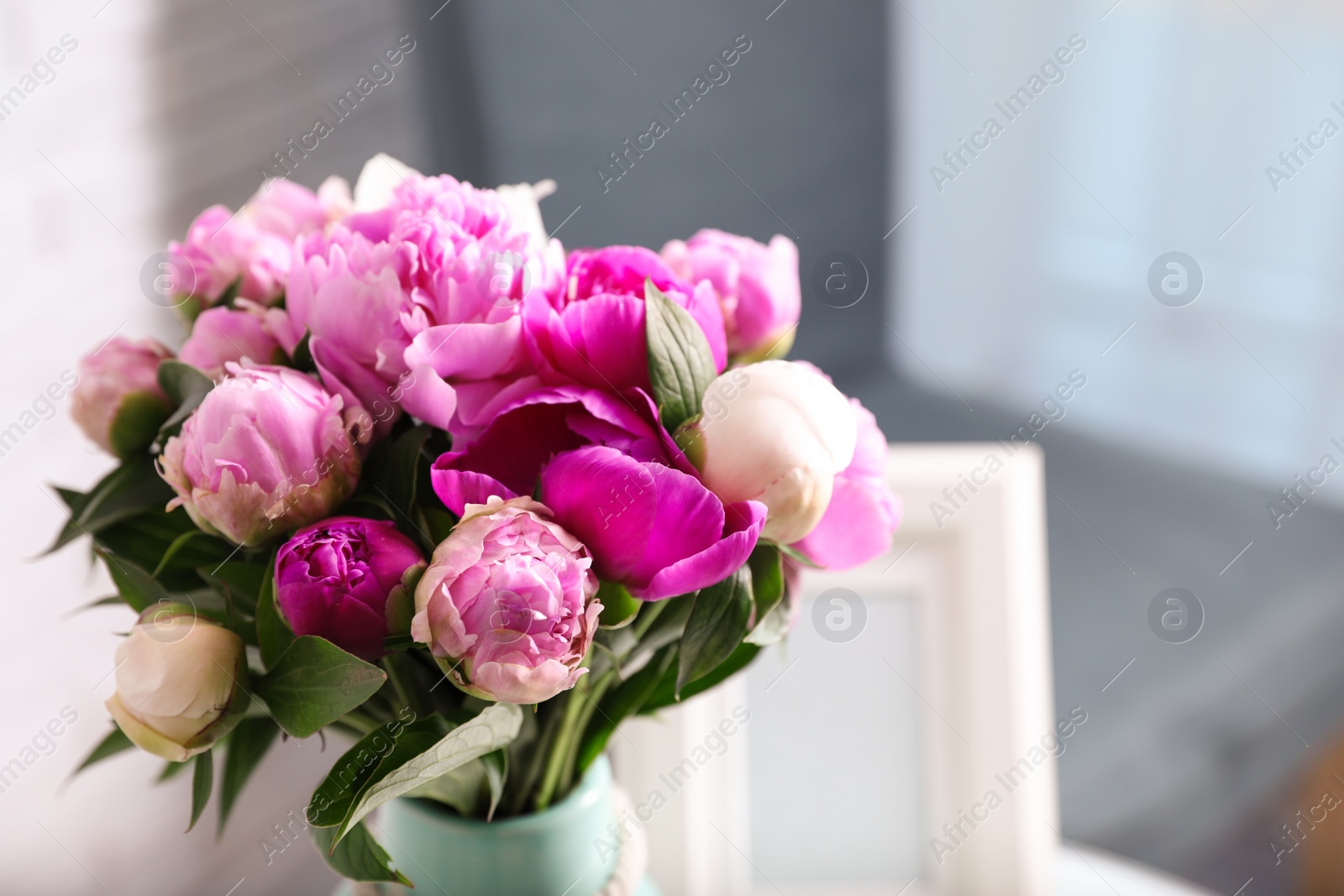 Photo of Bouquet of beautiful peonies in room, space for text