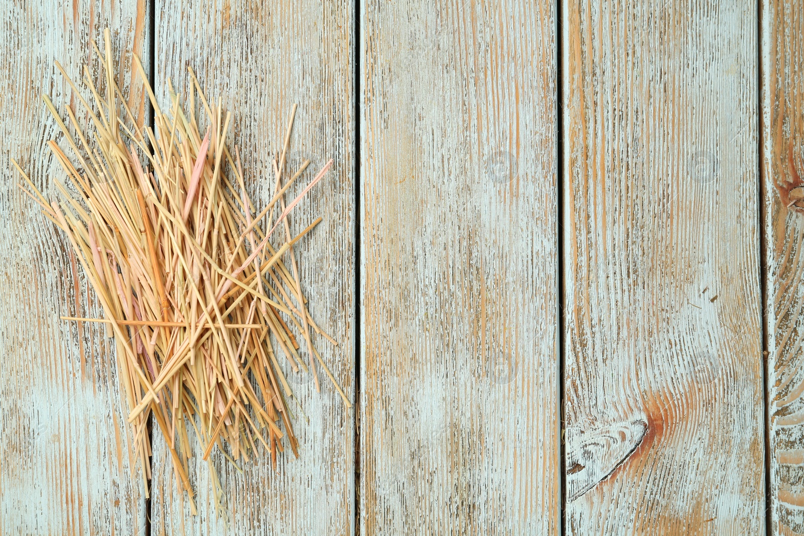 Photo of Heap of dried hay on light wooden background, flat lay. Space for text