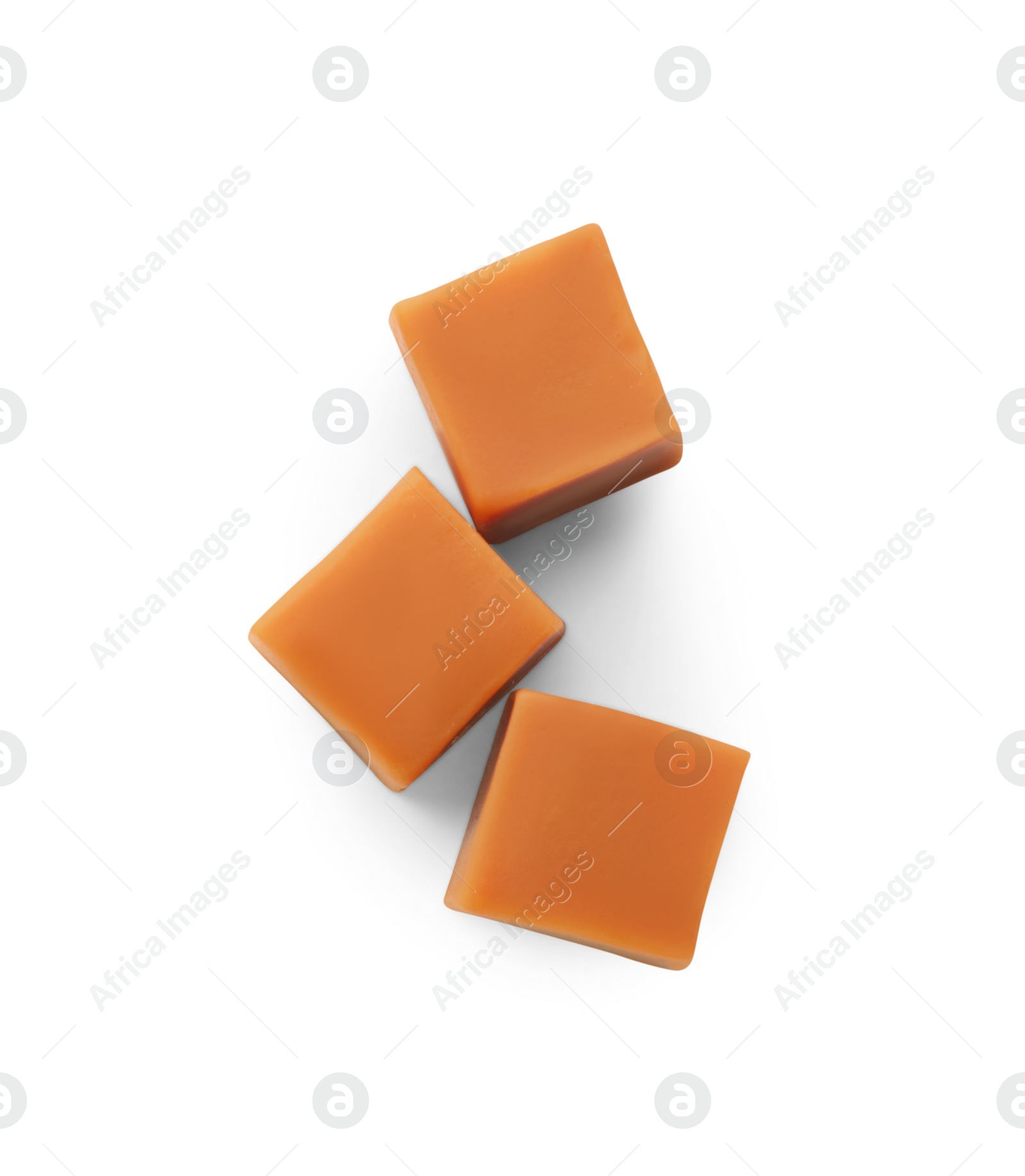 Photo of Heap of caramel candies on white background, top view
