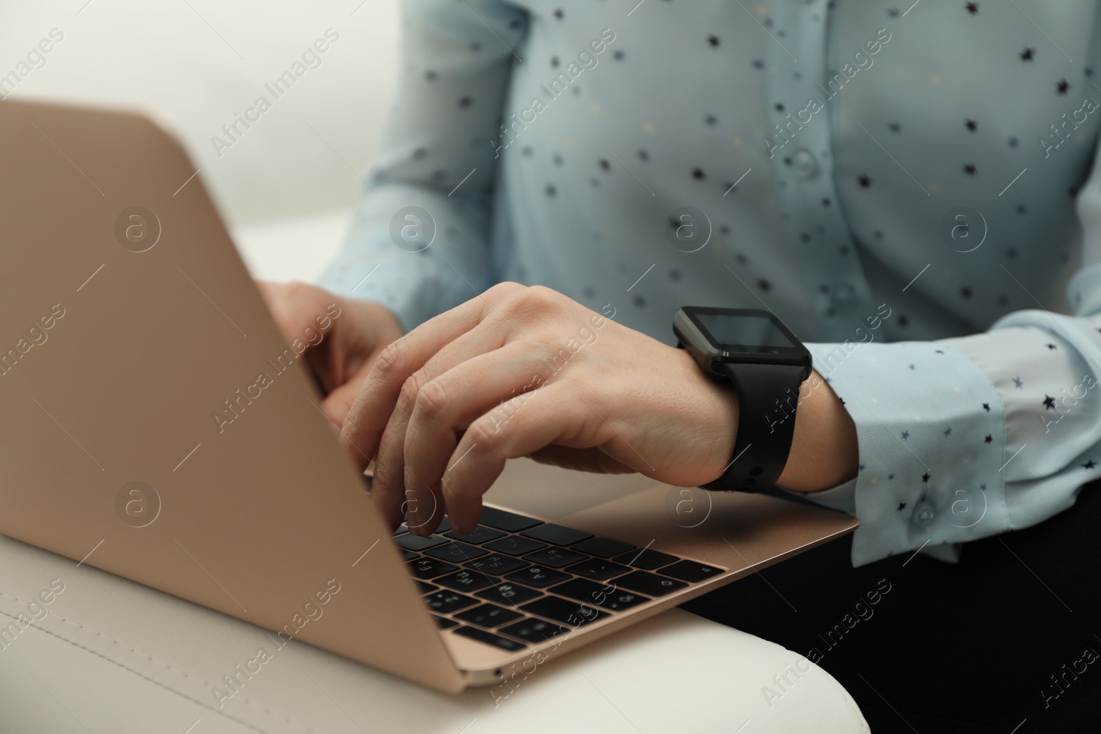 Photo of Mature woman with smart watch working on laptop indoors, closeup