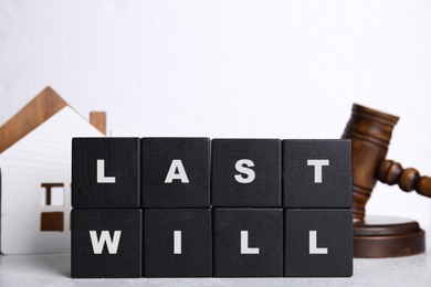 Photo of Black cubes with words Last Will on white background
