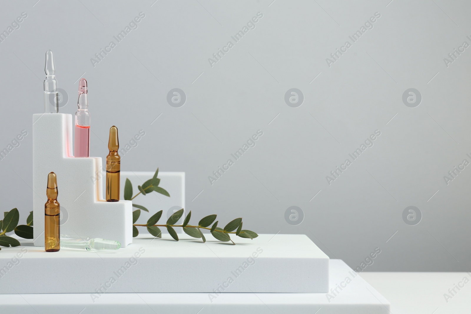 Photo of Stylish presentation of different skincare ampoules on white background. Space for text