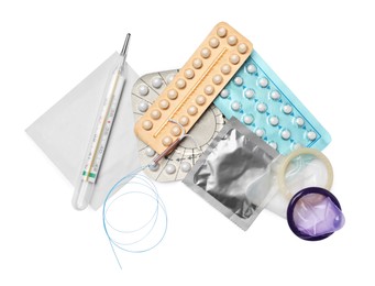 Photo of Contraceptive pills, condoms, intrauterine device and thermometer isolated on white, top view. Different birth control methods