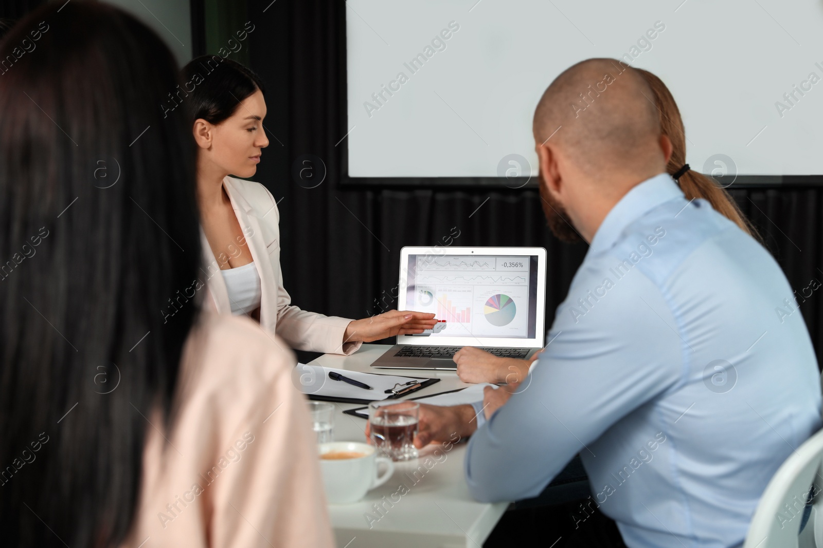 Photo of Business people having meeting in conference room with video projection screen