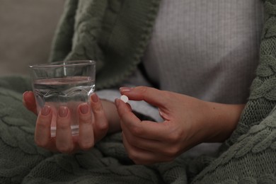 Photo of Woman with antidepressant pill and glass of water, closeup