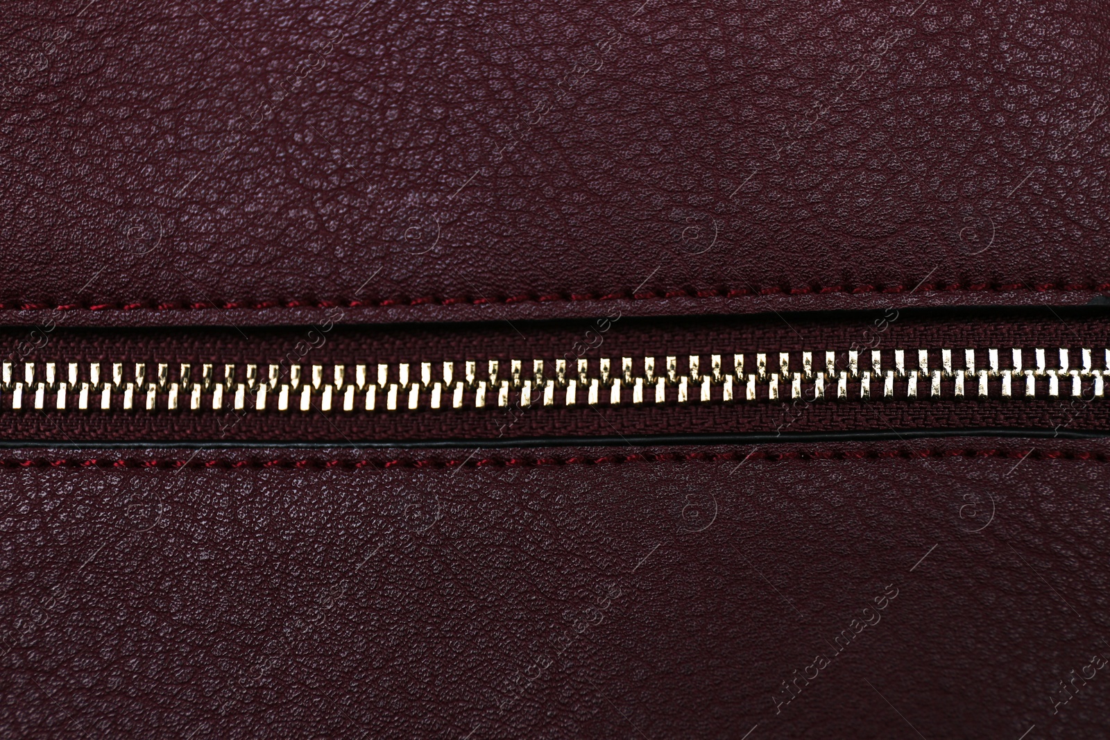 Photo of Burgundy leather fabric with zipper as background, top view