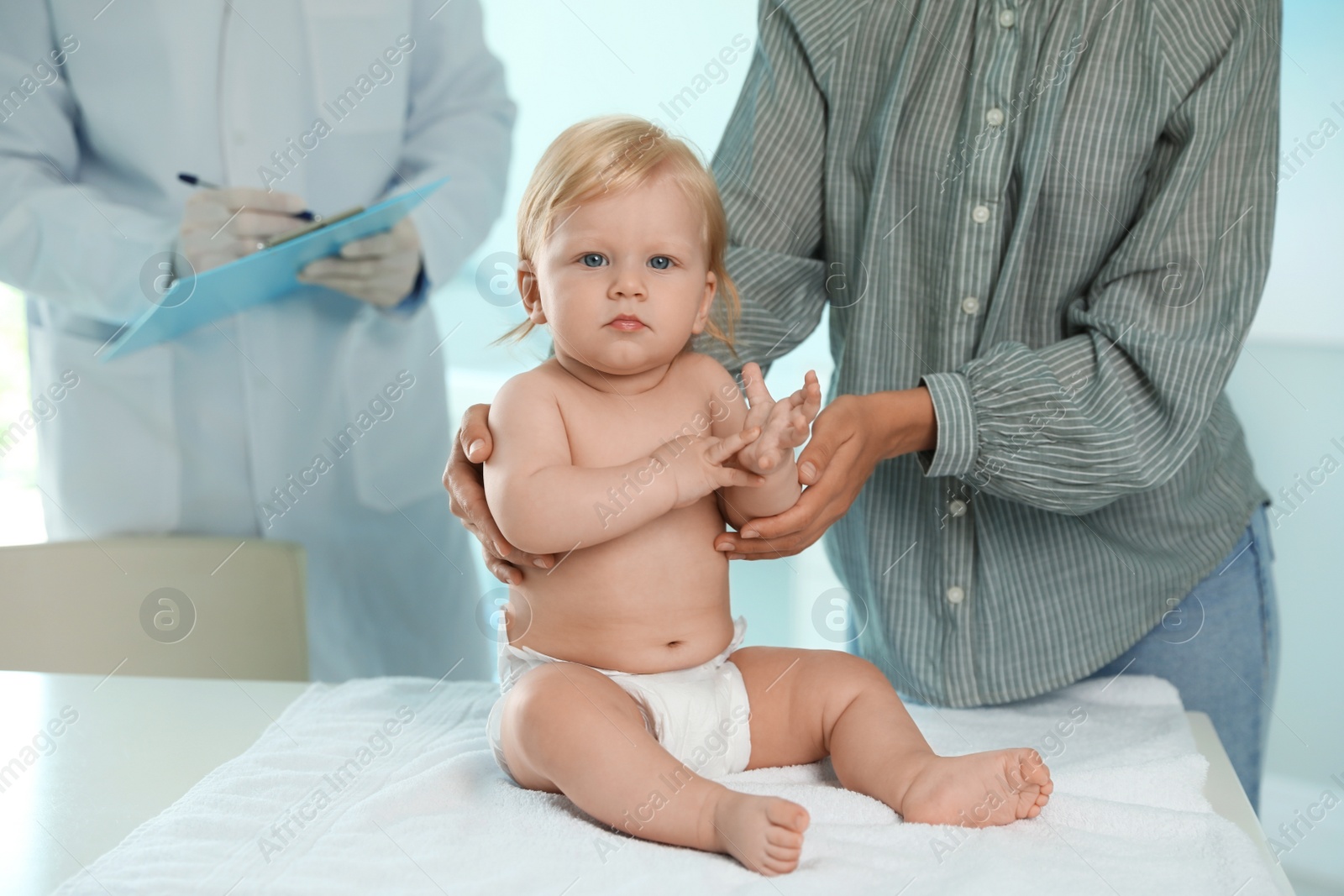 Photo of Mother with her baby visiting pediatrician in hospital. Health growth