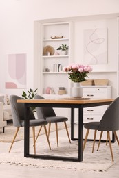 Photo of Stylish dining room with cosy furniture and flowers