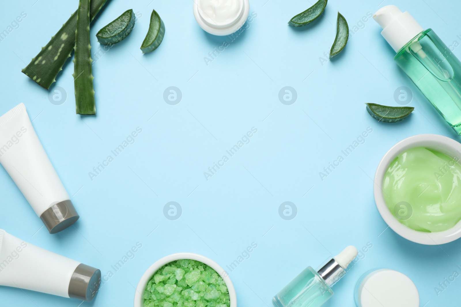 Photo of Flat lay composition with different cosmetic products and aloe on light blue background, space for text