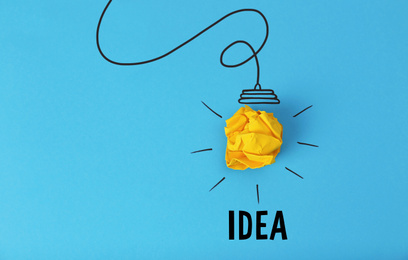 Image of Idea concept. Composition with crumpled paper ball and drawing of lamp bulb on blue background, top view