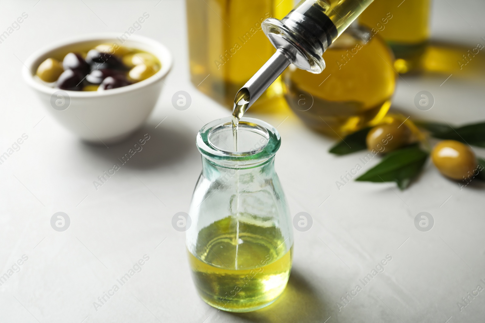 Photo of Pouring fresh olive oil into bottle on table