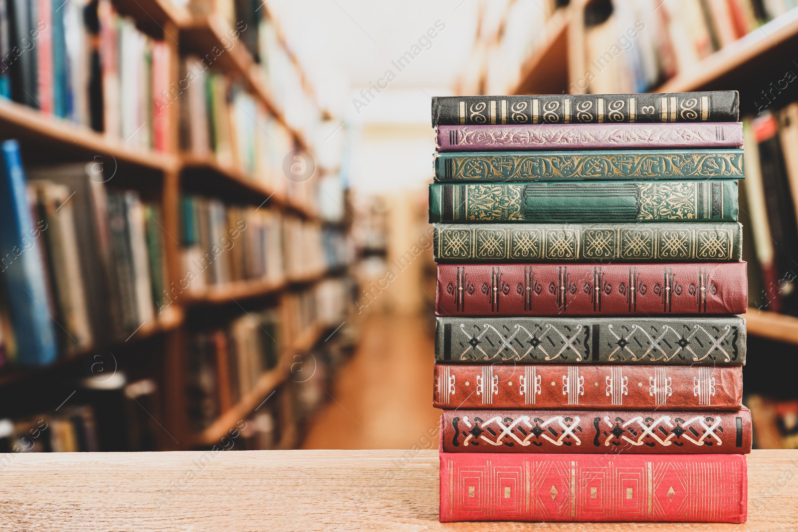 Image of Stack of old vintage books on table in library, space for text 
