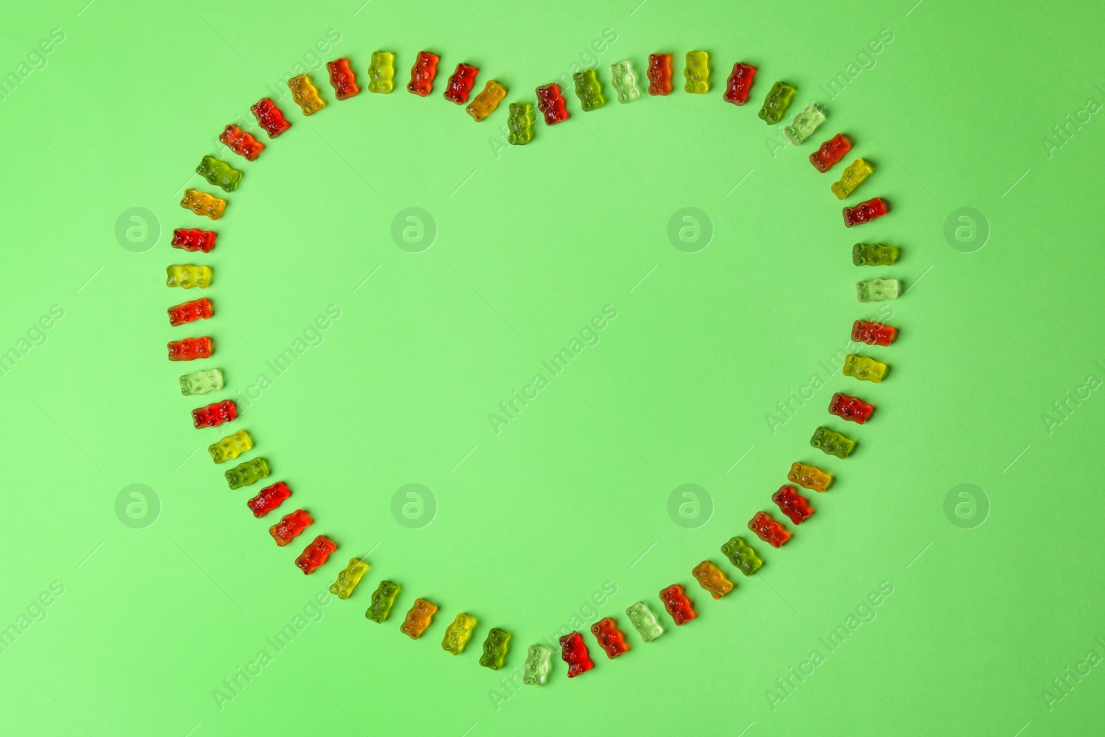 Photo of Flat lay composition with delicious jelly bears on color background. Space for text