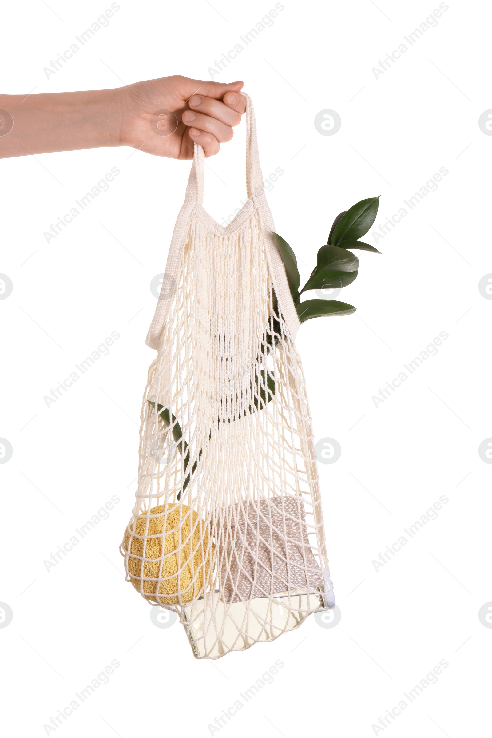 Photo of Woman holding net bag with different items on white background, closeup. Conscious consumption