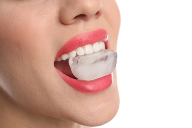 Photo of Young woman holding ice cube in mouth on white background, closeup