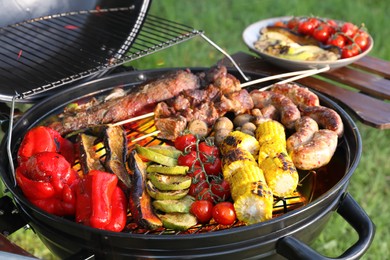 Image of Tasty meat and vegetables on barbecue grill outdoors