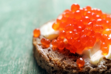 Delicious sandwich with red caviar, closeup