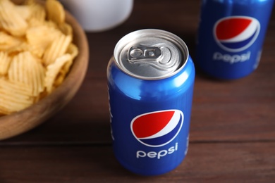 MYKOLAIV, UKRAINE - FEBRUARY 15, 2021: Can of Pepsi and snack on wooden table